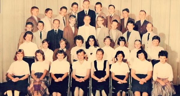 Group of school children in uniform from a vintage classroom photo, capturing a nostalgic moment in educational history.