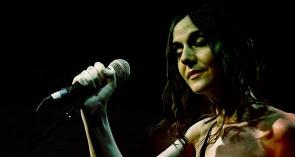 Vintage female singer performing with microphone on stage, capturing classic music and entertainment moments.