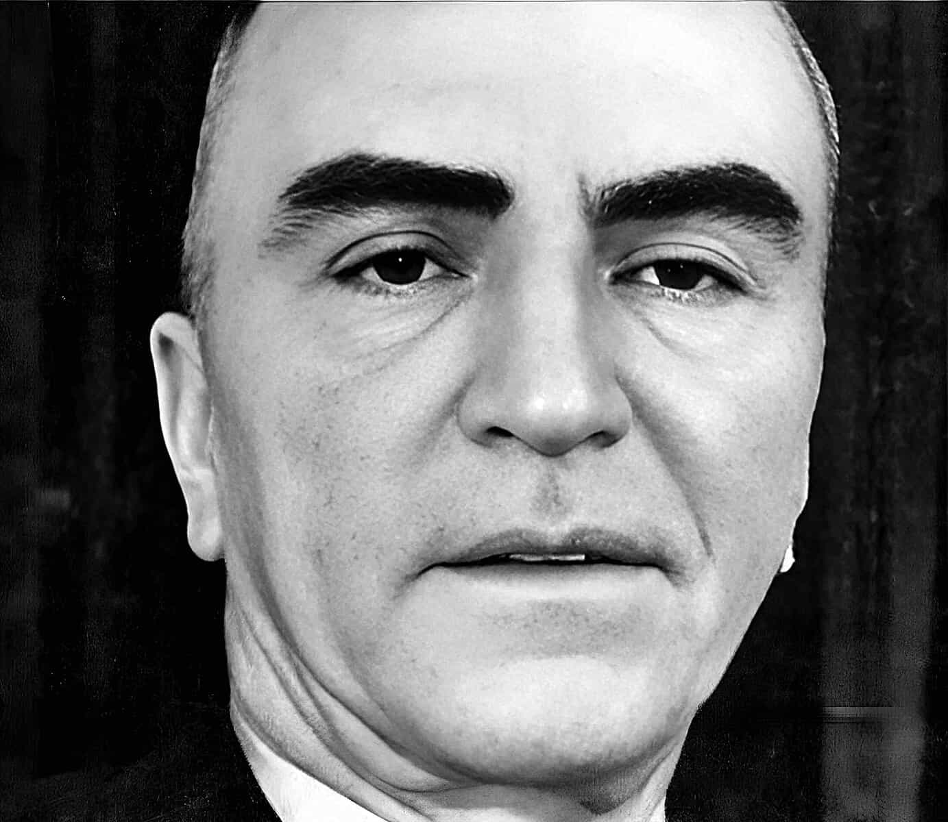 Close-up black and white portrait of a middle-aged man with a serious expression, emphasizing historical and news archive themes from Past Daily.