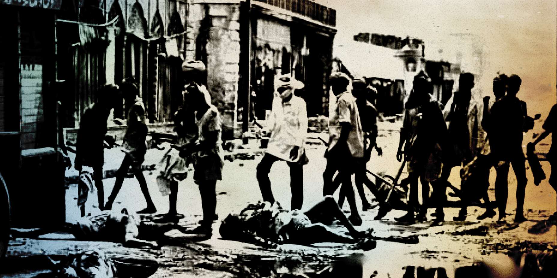 Damaged street scene showing civilians and a fallen person during wartime, with debris and destruction on a city street, capturing historical conflict and its impact on urban environments.