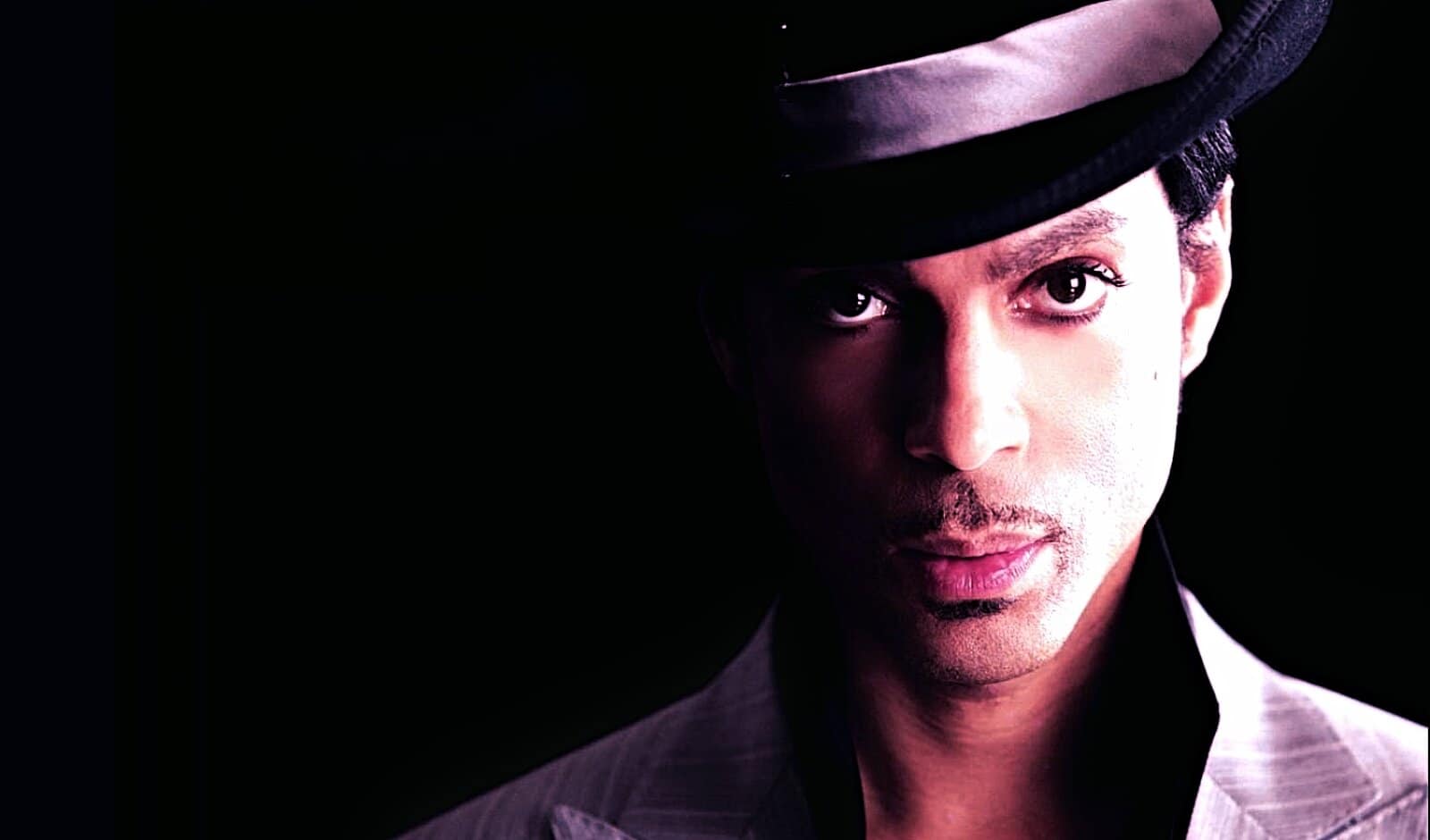 Vintage jazz musician wearing a fedora, music archive, news, and history sound recordings, Past Daily: A Sound Archive of News, History And Music, black background, nostalgic music memorabilia, audio history, radio broadcast, cultural heritage, podcast archive, audio preservation, sound recording collection, retro music, oldies, media archive, historic radio programs, media history, vintage music photograph, audio history archive, music nostalgia, historic sound archive relevance.