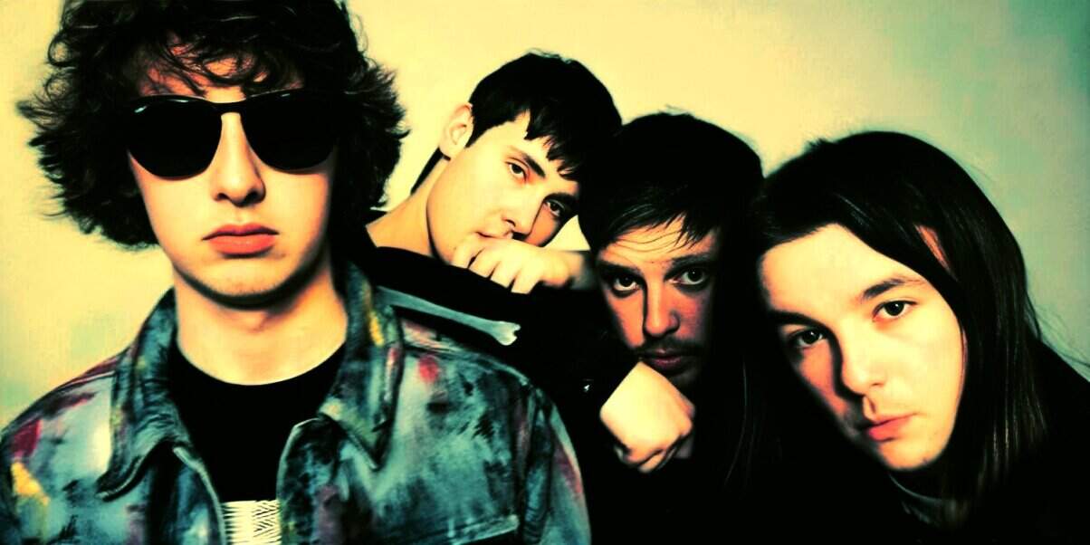 Young indie band members posing together in a colorful, artistic photo for a music archive and historical sound collection.