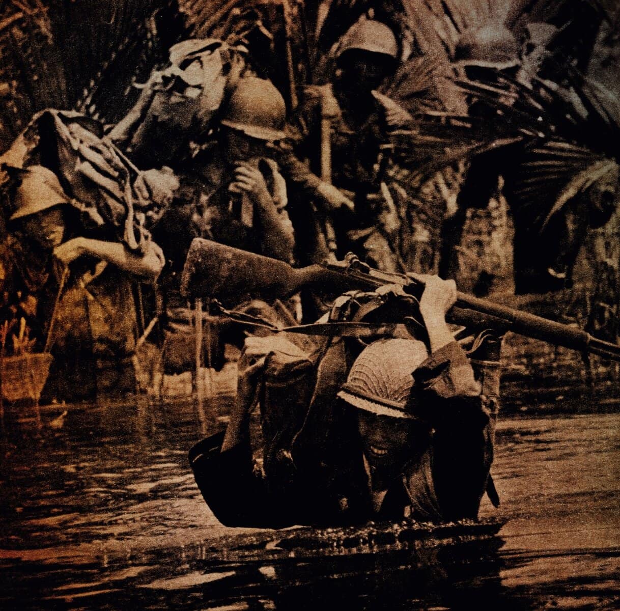 Historic wartime photograph of soldiers crossing water with rifles and gear, capturing a moment of military history, war narratives, and news from past conflicts, emphasizing historical news archives and military music collections.