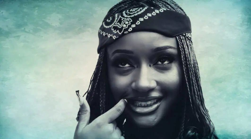 Smile of a young woman with braided hair and a bandana, showcasing a joyful expression, reflecting the vibrant history and music archives from Past Daily.